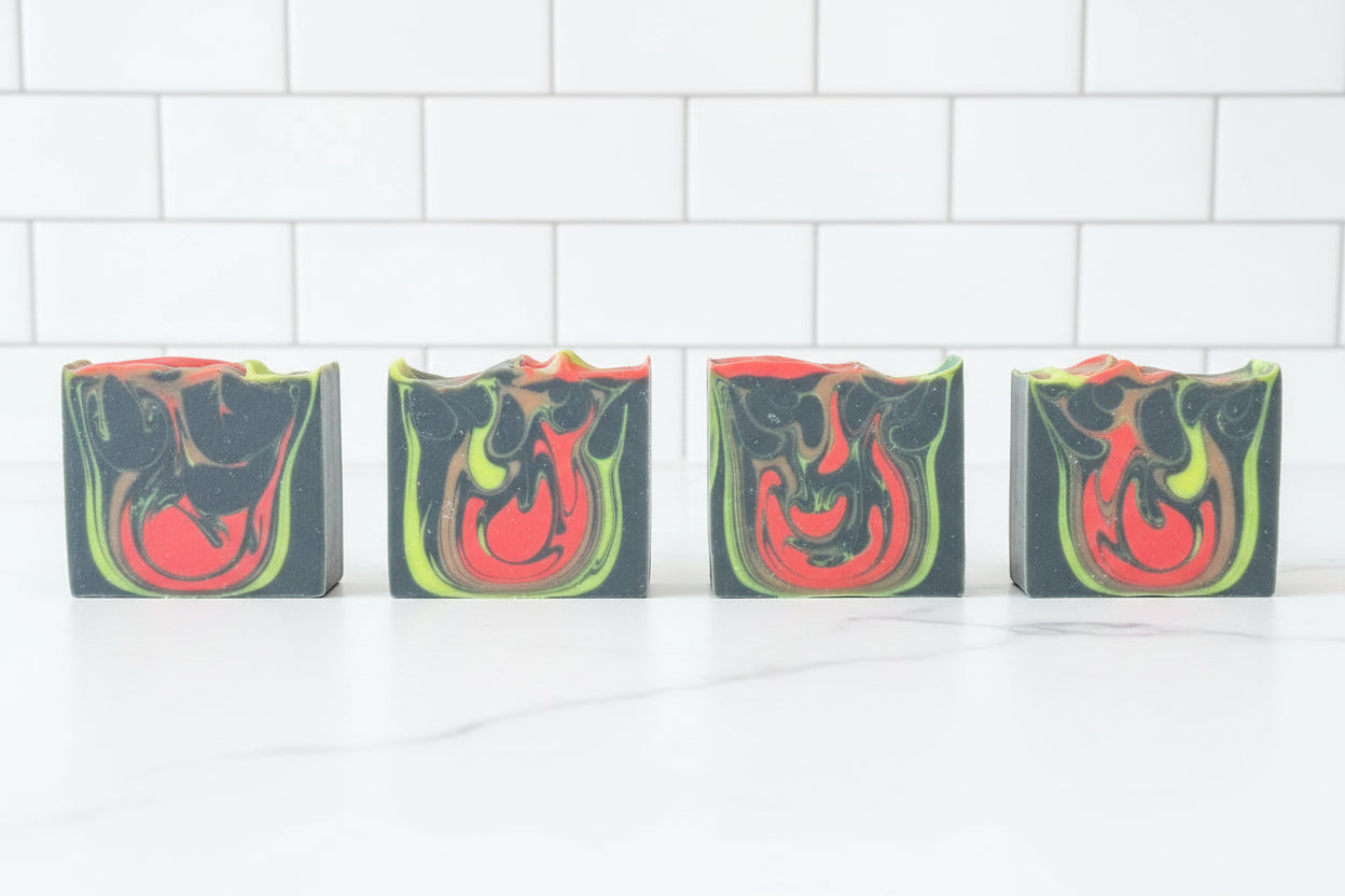 Four soap bars with colorful swirl patterns on a white background