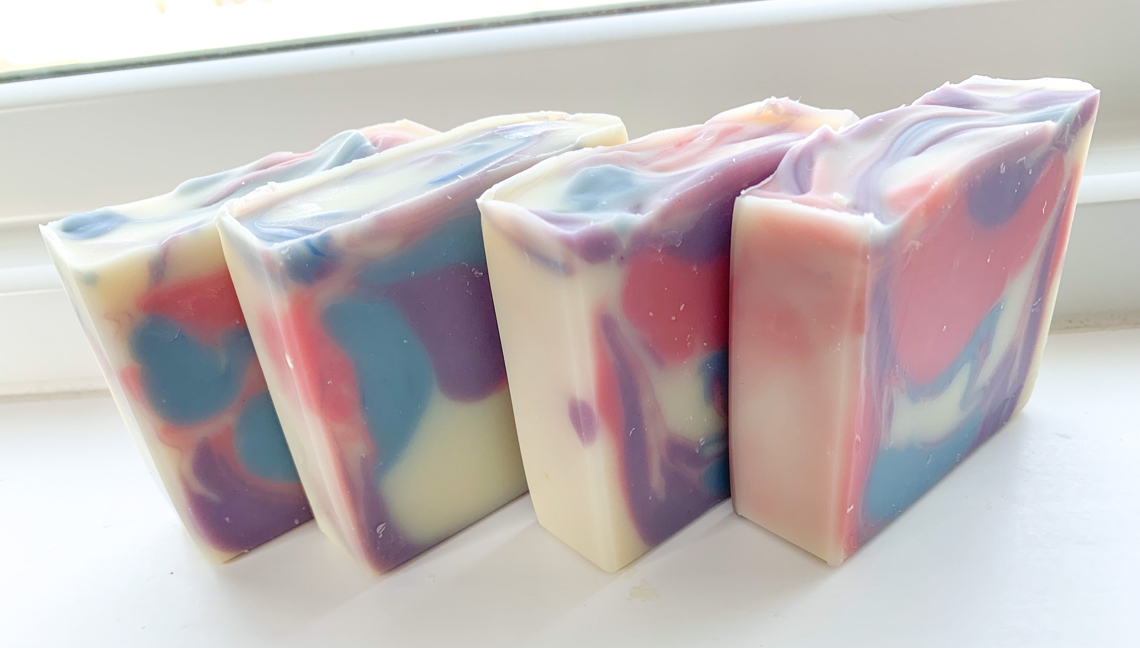 Square bar soap with pink, purple and blue swirls in a white base