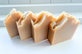 four orange soaps on a white surface