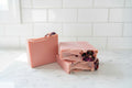Pink soap bars with visible floral elements on a white background