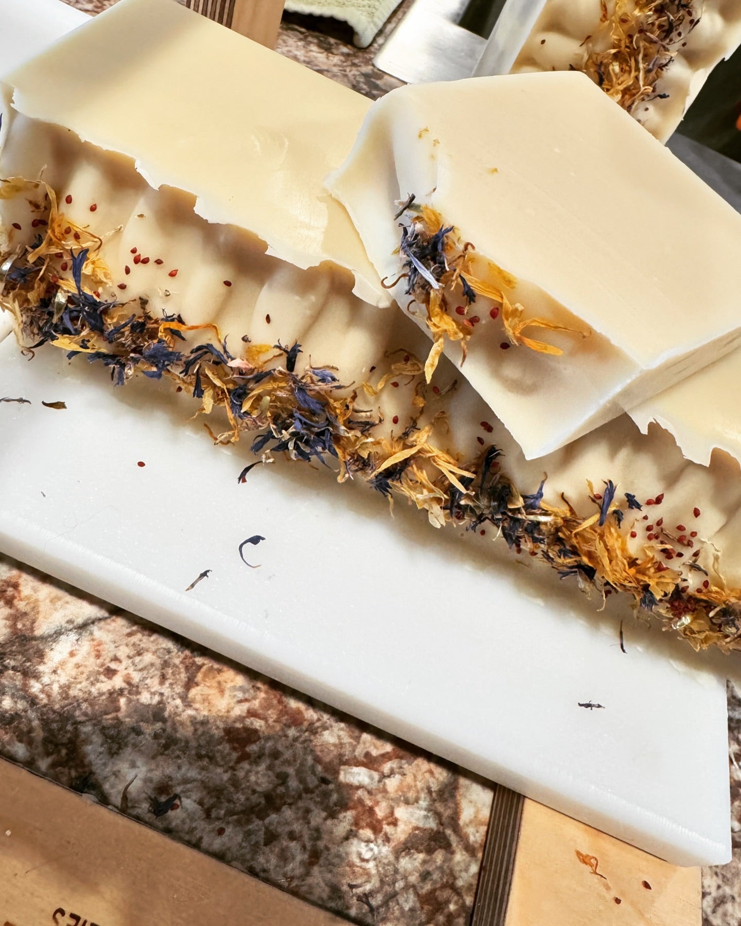 No color added bar soap with floral elements on a cutting board