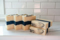 5 black and white striped bars on a white surface. this bar soap glows in the dark when activated by sunlight