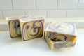 four bar soaps with yellow and purple swirls on a white background